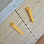 Yellow cabinet handles on a wooden surface