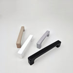 Four cabinet handles in different colors on a white background