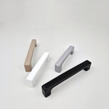 Four cabinet handles in different colors on a white background