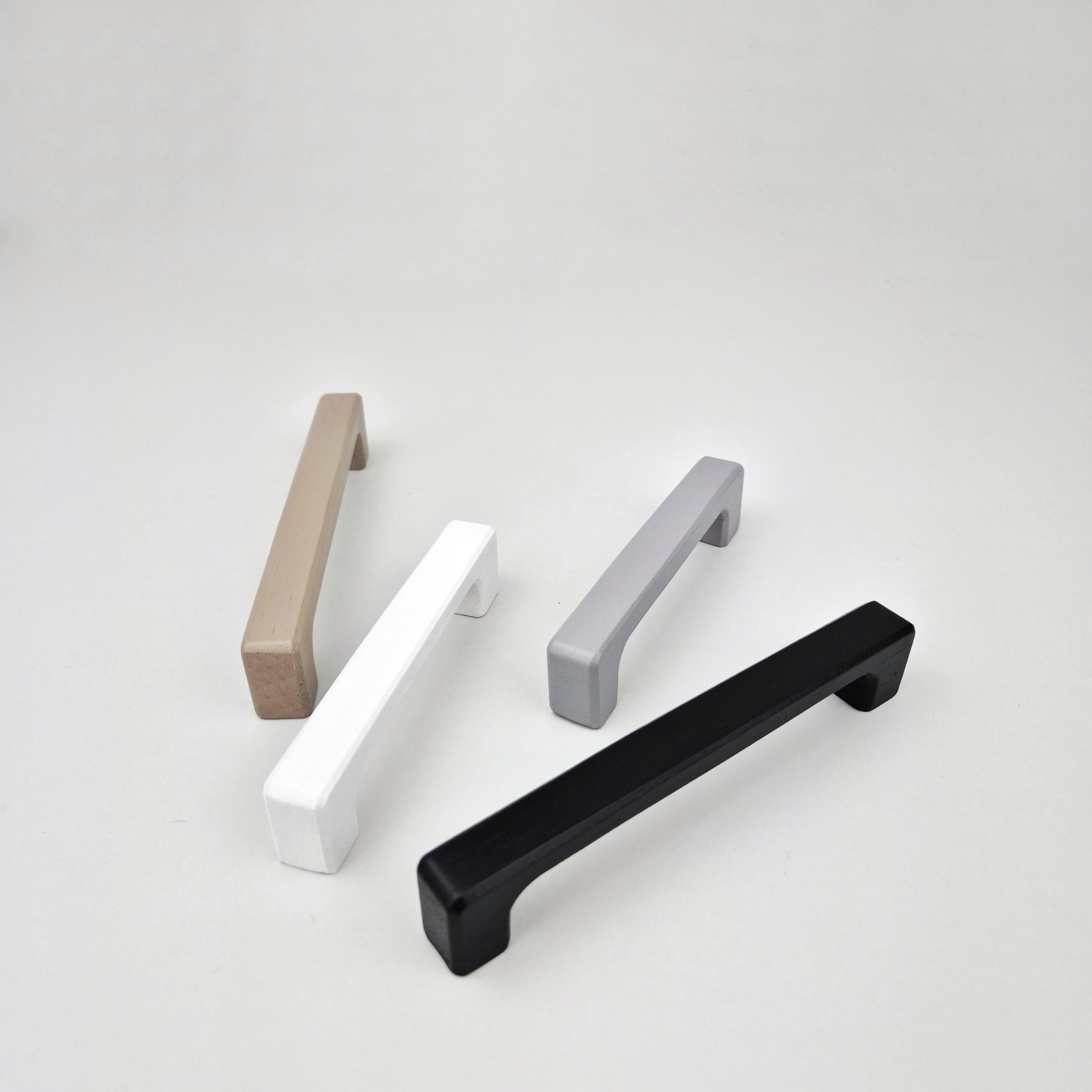 Four cabinet handles in different colors on a white background