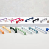 Set of colorful cabinet handles on a light gray background