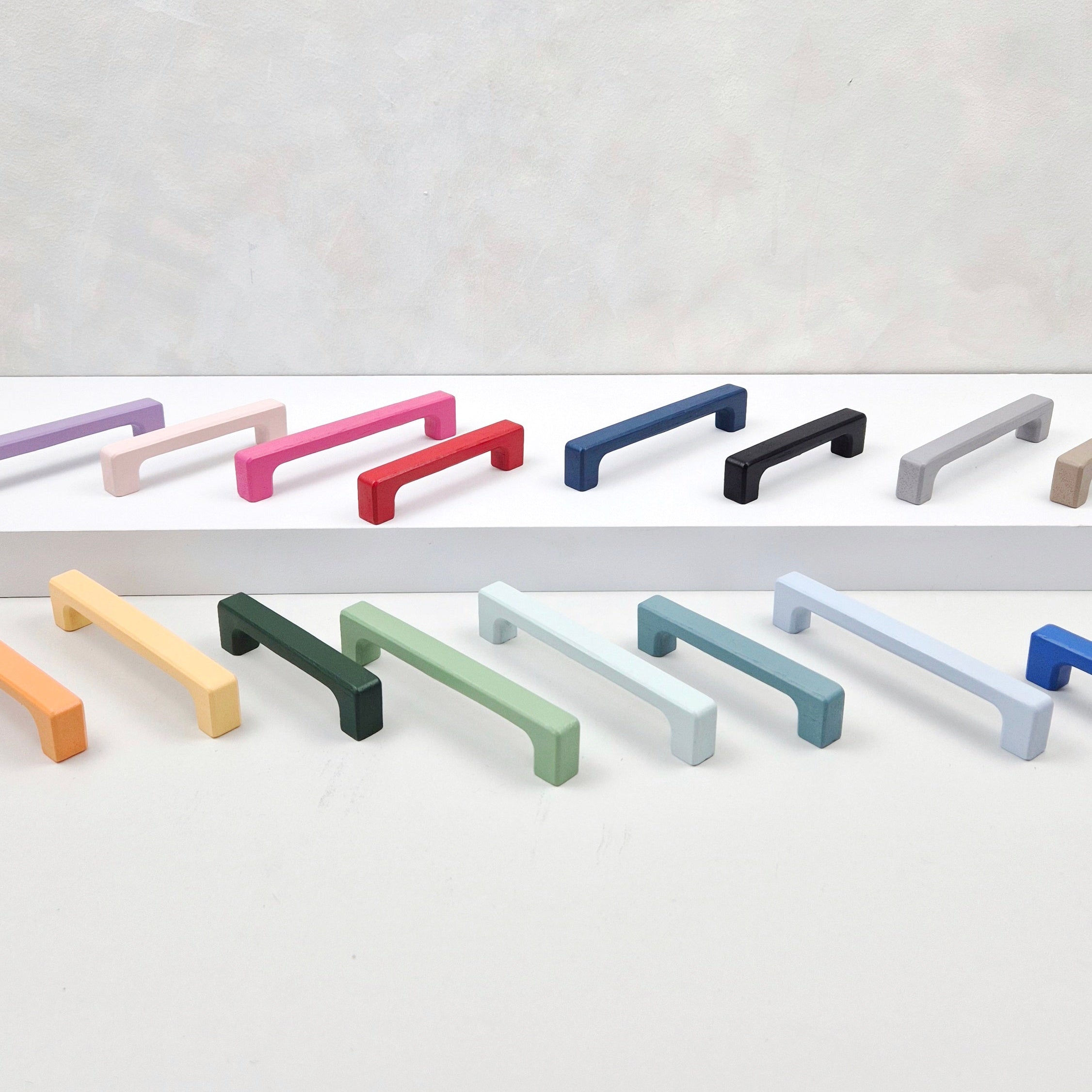 Set of colorful cabinet handles on a light gray background