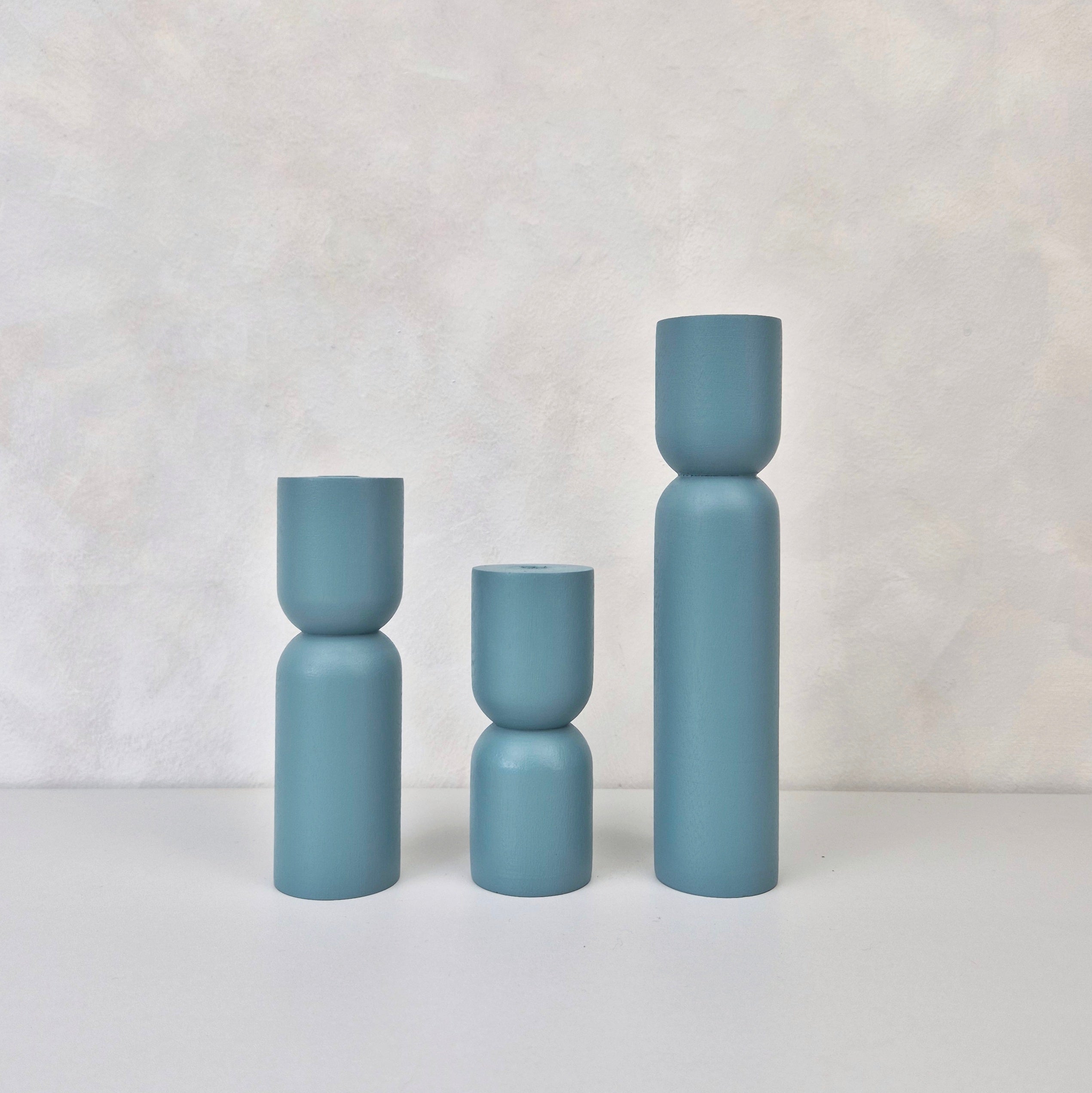 Three hourglass-shaped decorative vases in blue, showcasing modern design and perfect for home decor.