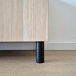 Black Ball furniture leg supporting a wooden cabinet, showcasing a modern and stylish design.