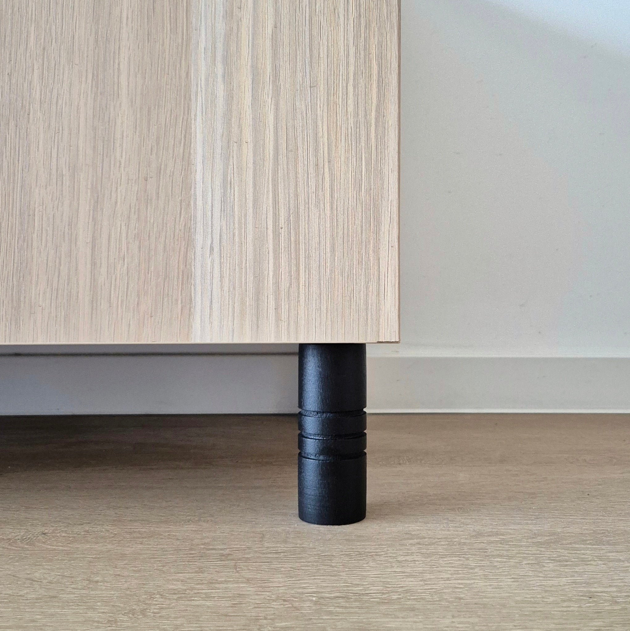 Black Ball furniture leg supporting a wooden cabinet, showcasing a modern and stylish design.