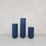 Three navy blue decorative vases of varying heights on a neutral background, perfect for home decor.