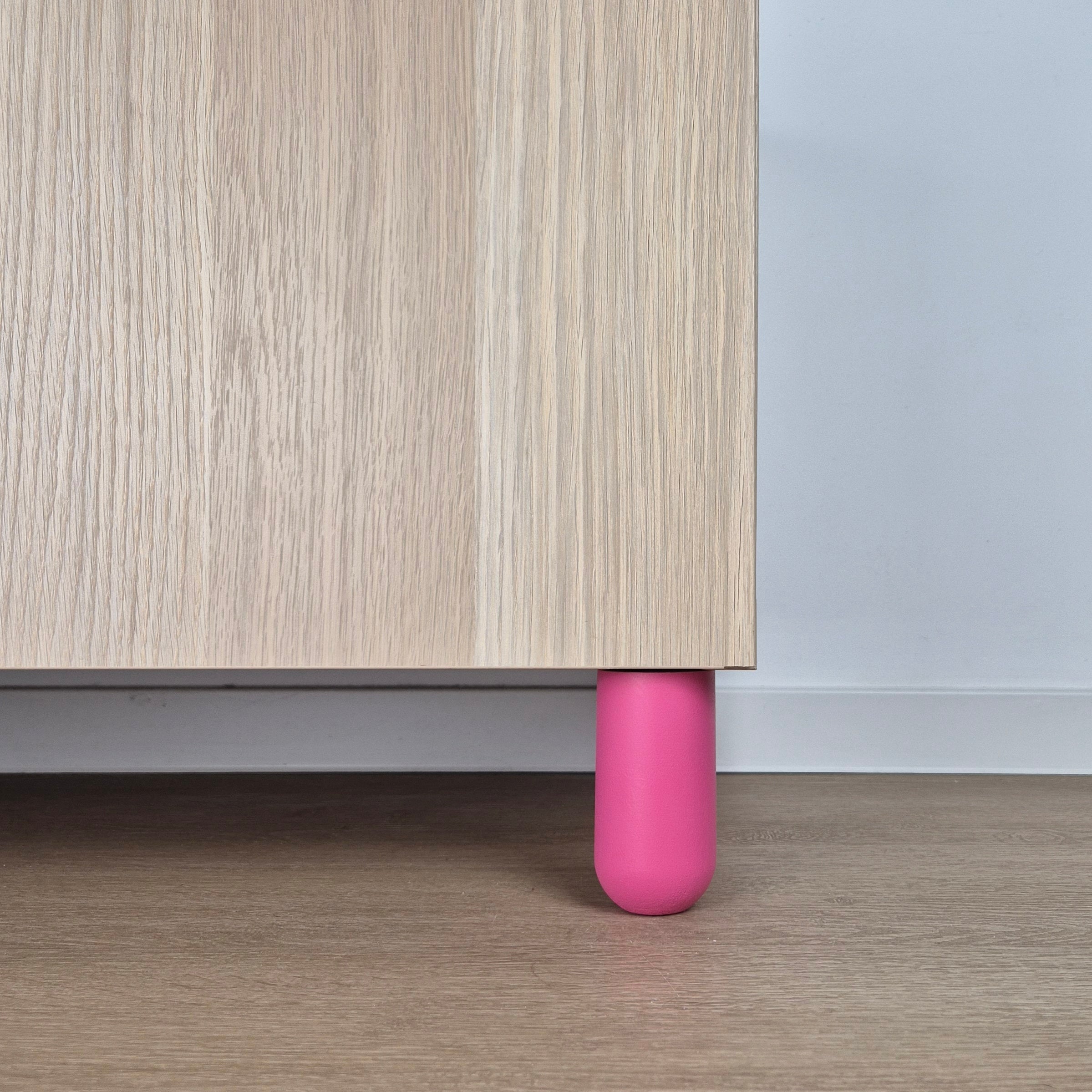 Colorful pink ball furniture leg supporting a kids' room furniture with wooden surface.