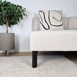 Furniture legs ARC showcased under a light sofa with a patterned cushion, featuring a wood ball furniture leg design.