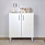 Light blue cabinet handle on a white cabinet in a kids' room with decorative items and toys.