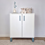 Turquoise cabinet handle on a modern white cabinet with stuffed animals and decor elements.