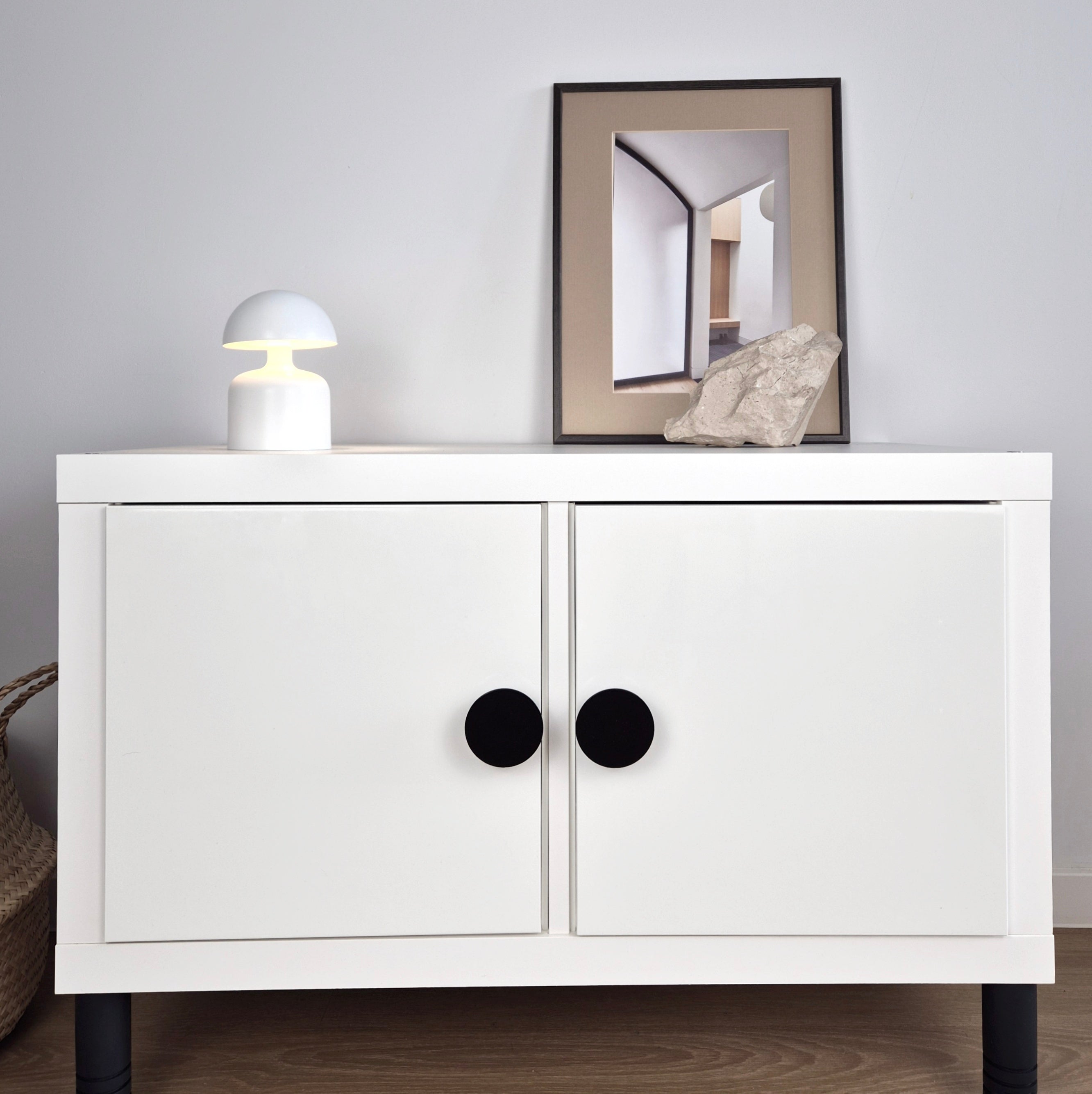 White cabinet with black knobs and legs