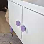 Purple round knob on white IKEA cabinet