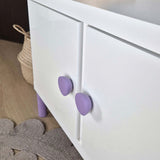 Purple round knob on white IKEA cabinet
