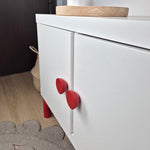 White cabinet with red round knobs