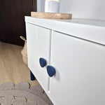 White cabinet with dark blue round knobs