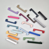 Set of colorful cabinet handles on a light gray background