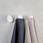 White wall hooks with linen towels