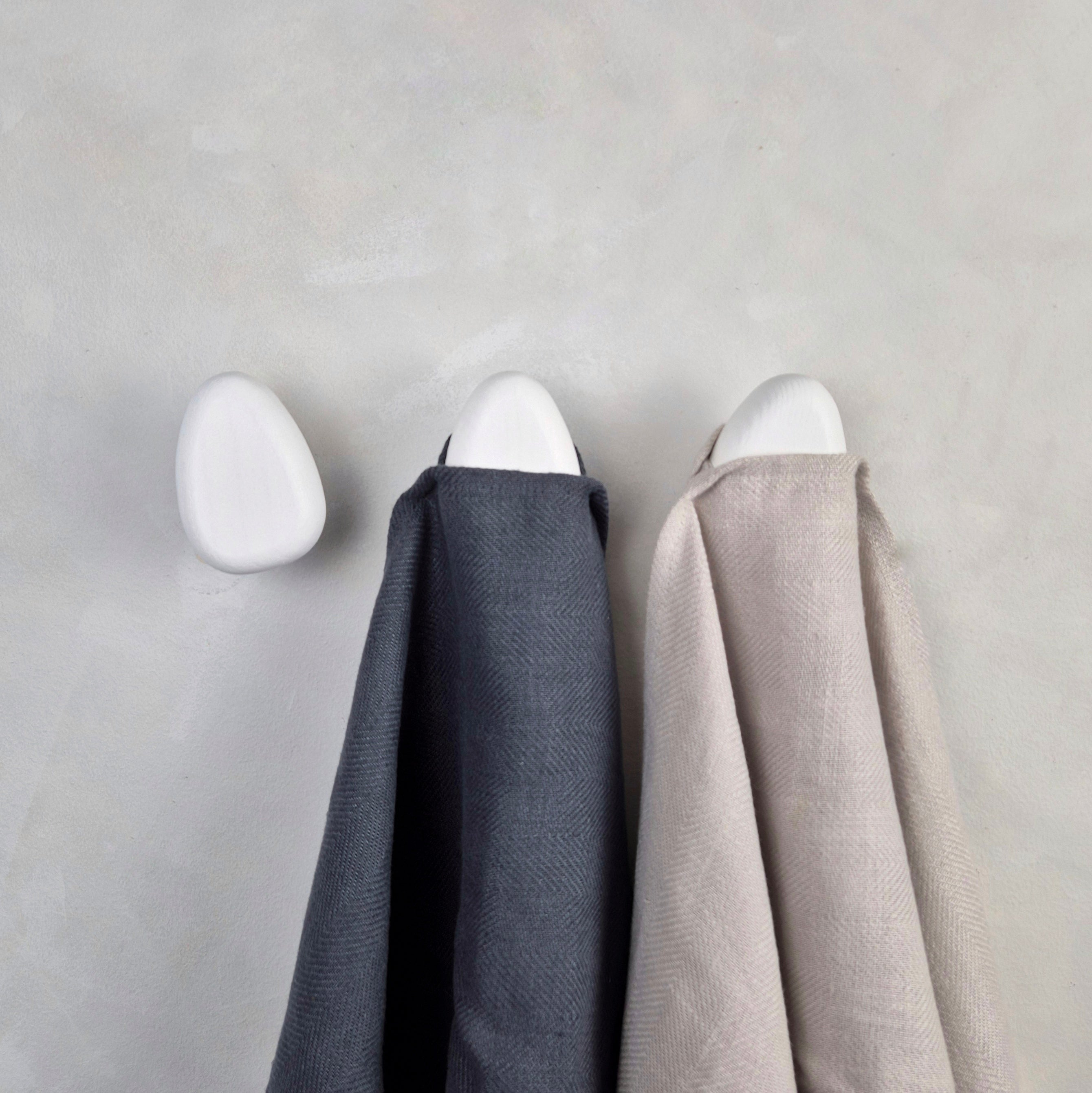 White wall hooks with linen towels