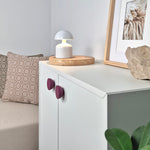 Plum round knobs on IKEA cabinet
