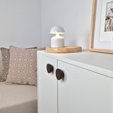 Brown flat round knobs on white cabinet