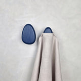 Dark blue wall hooks with hanged towel