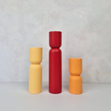 Colorful hourglass-shaped furniture legs in yellow, red, and orange, showcasing modern design for stylish furniture legs.