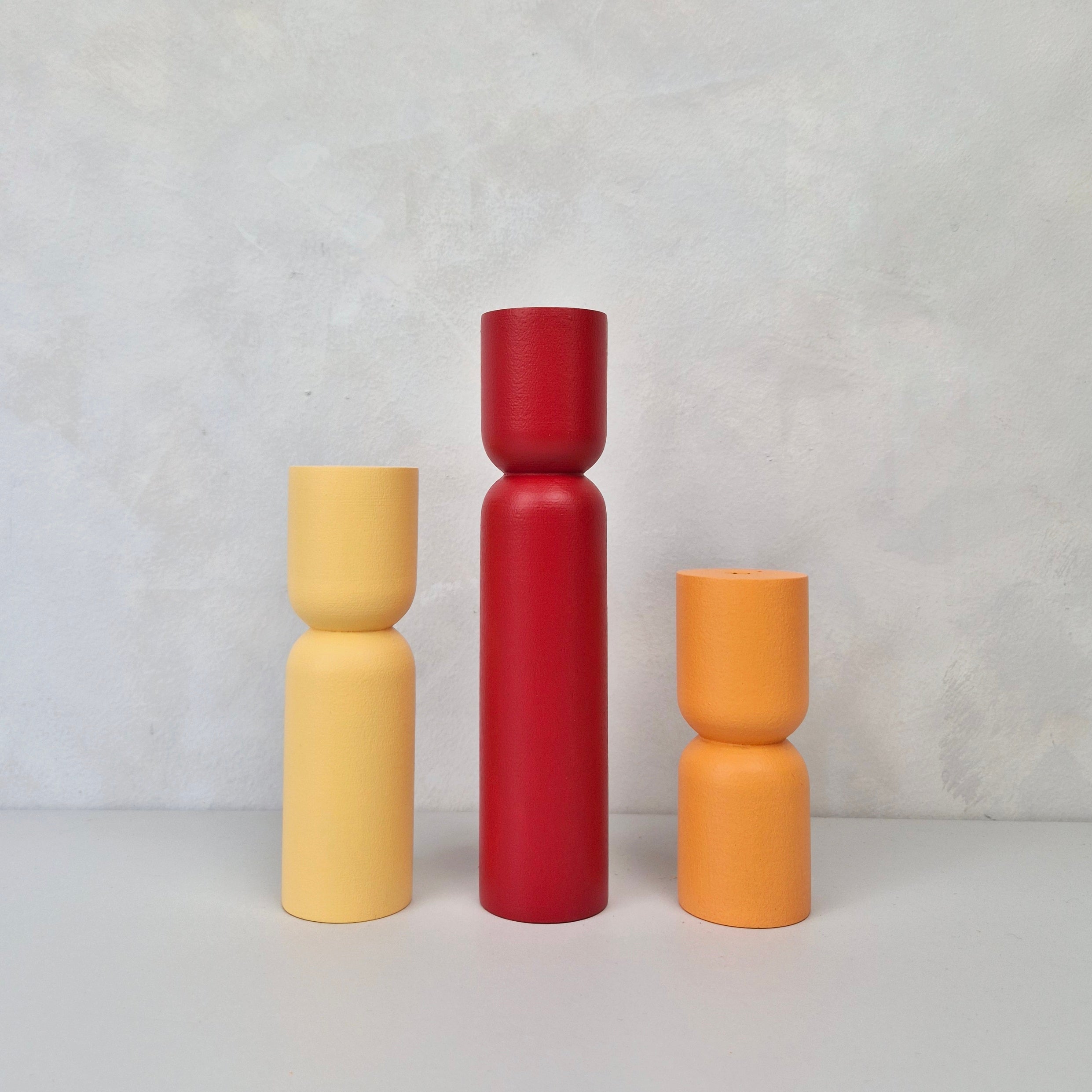 Colorful hourglass-shaped furniture legs in yellow, red, and orange, showcasing modern design for stylish furniture legs.