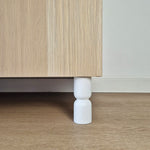 Hourglass shaped furniture legs for cabinets, designed to enhance style and support, made from solid wood in white color.