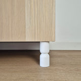 Hourglass shaped furniture legs for cabinets, designed to enhance style and support, made from solid wood in white color.