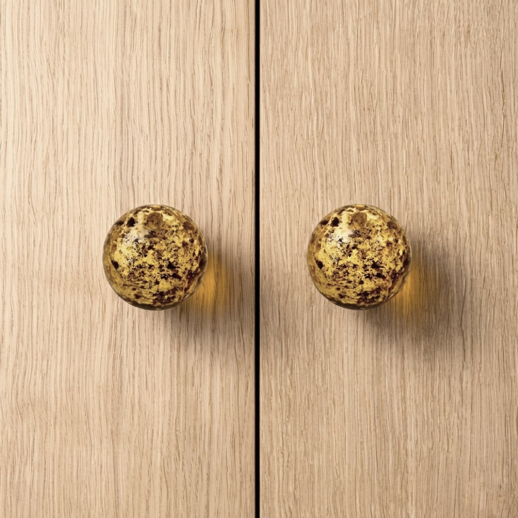 Round knob AMBER on wooden cabinet doors, showcasing luxurious amber material and modern design.