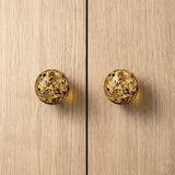 Round knob AMBER on wooden cabinet doors, showcasing luxurious amber material and modern design.