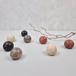 Various natural travertine cabinet knobs in earthy tones arranged on a table.