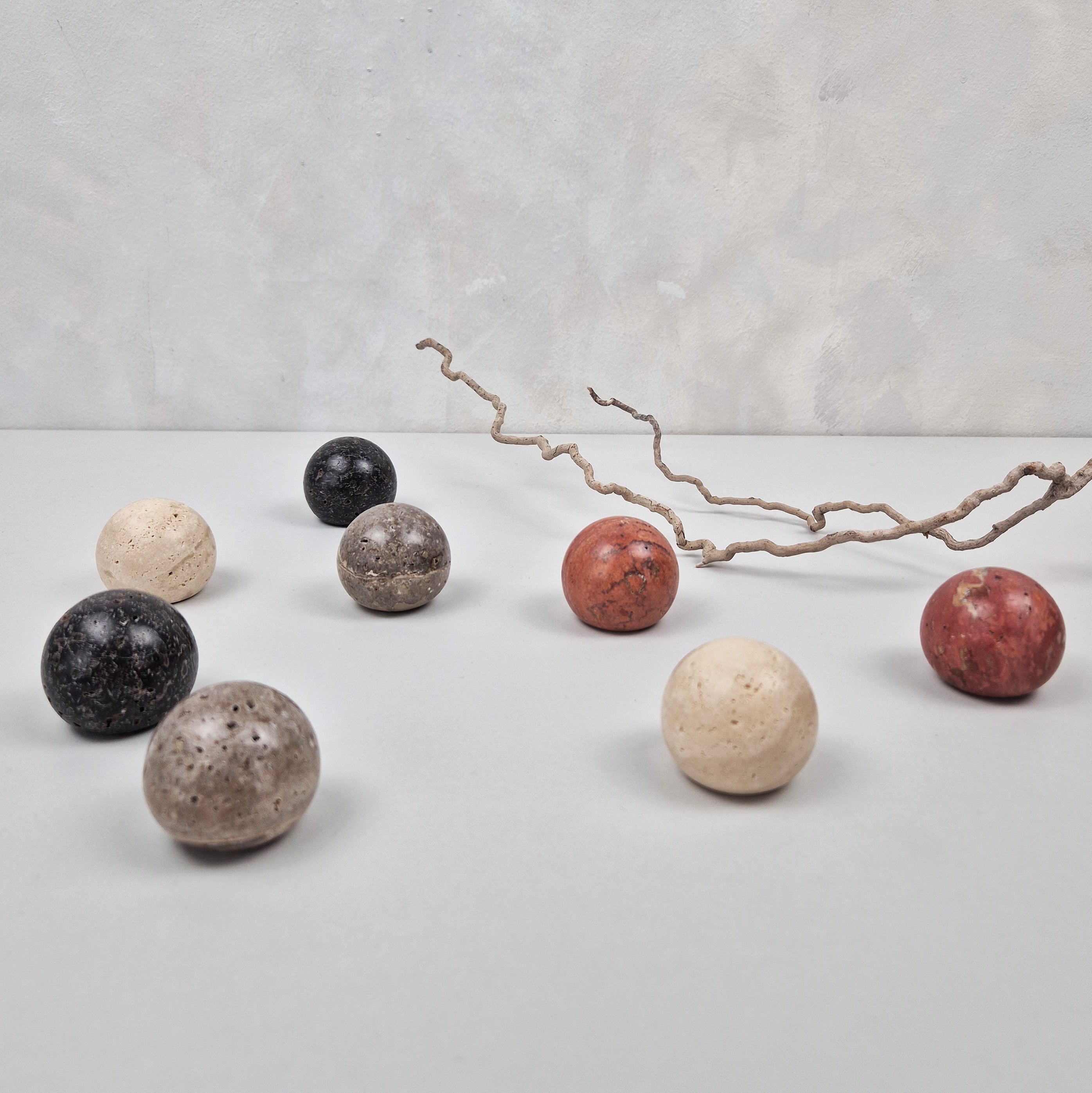 Various natural travertine cabinet knobs in earthy tones arranged on a table.