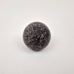 Black travertine cabinet knob close-up showing natural stone veining