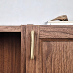 Brass cabinet pull showcased on a wooden cabinet, highlighting its elegant design and warm satin finish.