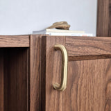 Brass cabinet pull on wooden cabinet showcasing elegant design and finish for functional home decor.