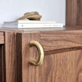 Brass cabinet pull on a wooden cabinet with books in the background, showcasing a stylish accent for furniture.