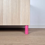Pink striped furniture leg supporting a wooden cabinet, ideal for modern interiors, featuring solid construction.