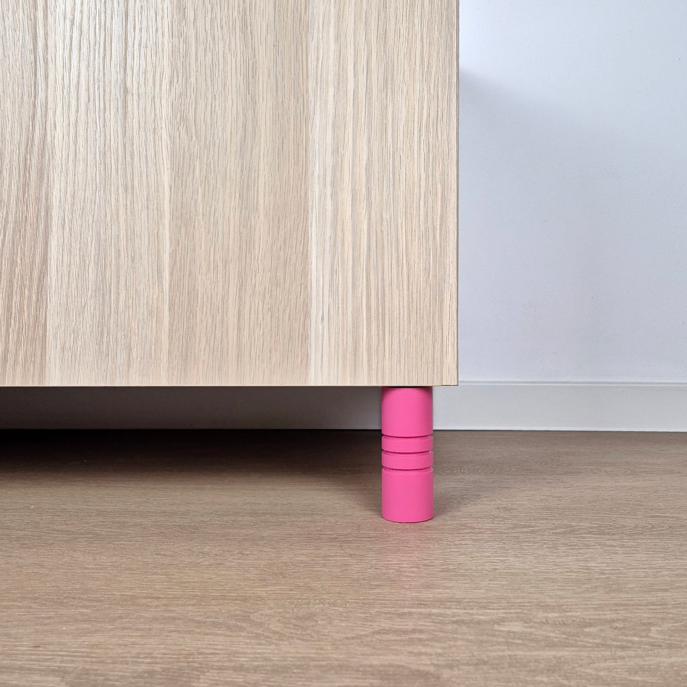 Pink striped furniture leg supporting a wooden cabinet, ideal for modern interiors, featuring solid construction.