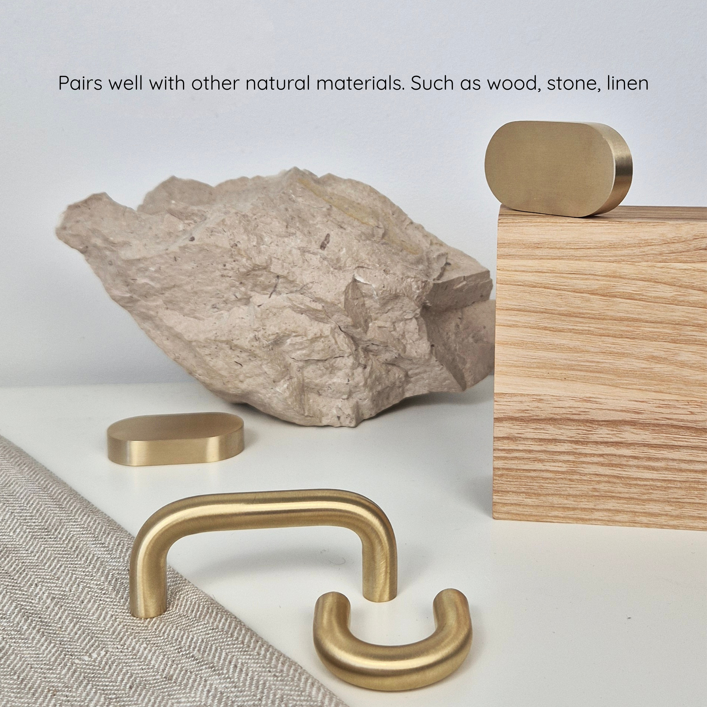Brass cabinet pull displayed with natural materials like wood and stone, showcasing its elegant design and finish.
